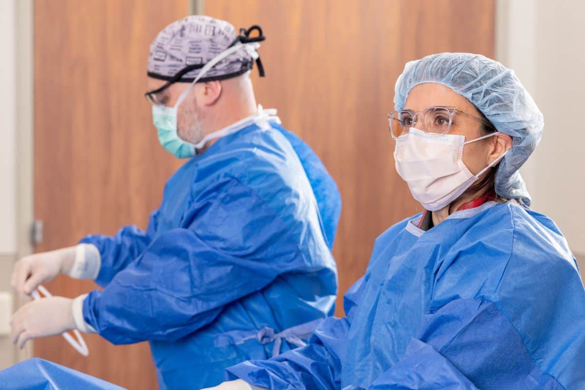 expert-implantable-loop-recorders Doctors in blue scrubs monitoring and performing implantable loop recorder procedure on patient at Oracle Heart and Vascular