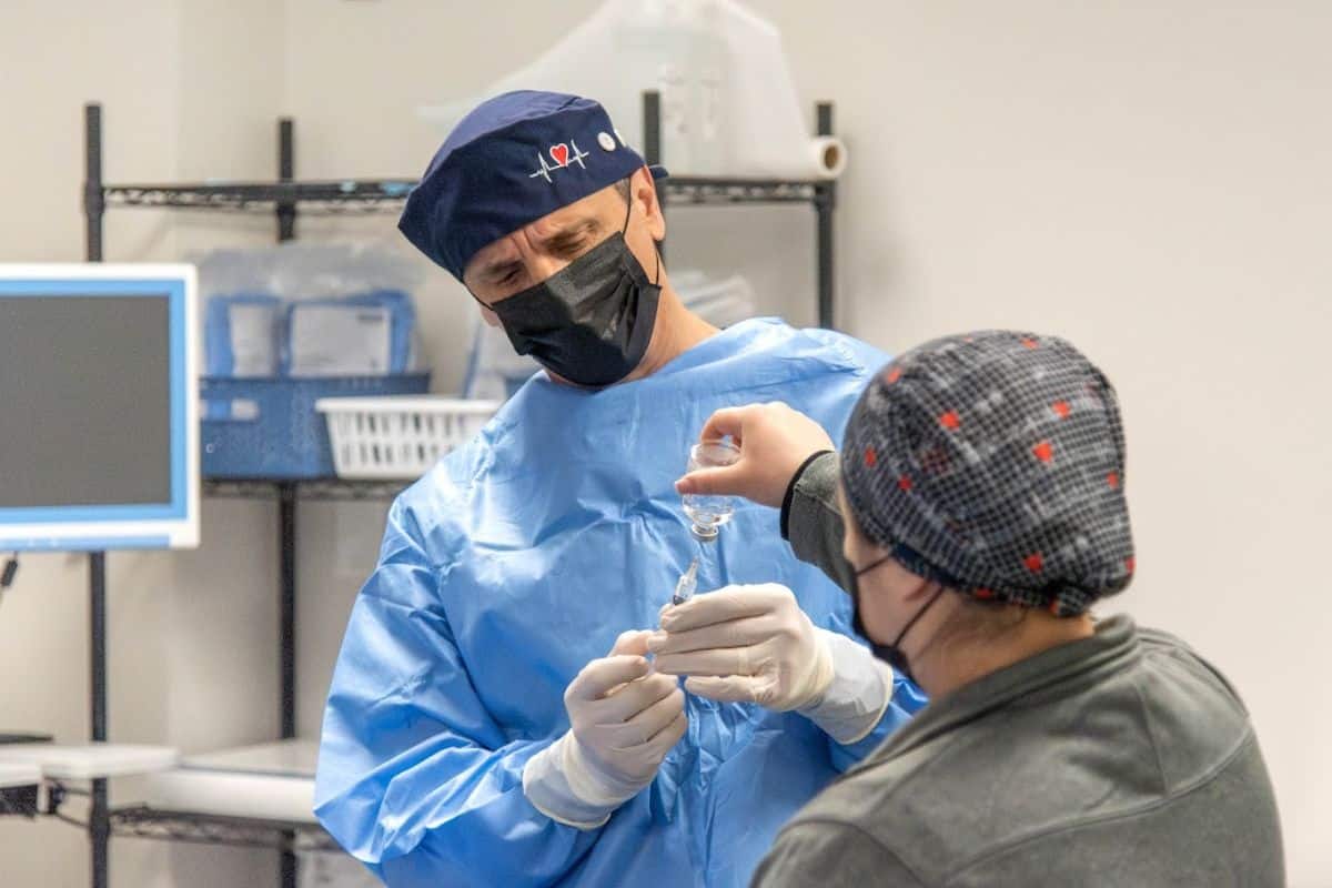 top-rated-atherectomy-fredericksburg (1) Doctor in blue scrubs and surgical cap preparing for an atherectomy procedure at Oracle Heart & Vascular Care near Fredericksburg and King George