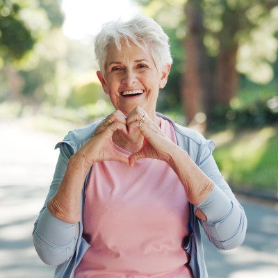 Older woman making heart shape with her hands, representing how the hearts electrical system works
