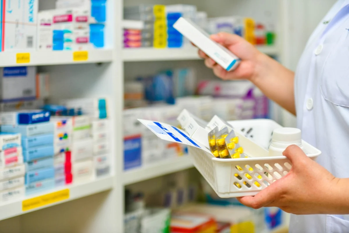 Oracle-heart-vascular-prescription-services Healthcare professional holding prescription medications in a tray while checking labels in a pharmacy or clinical setting