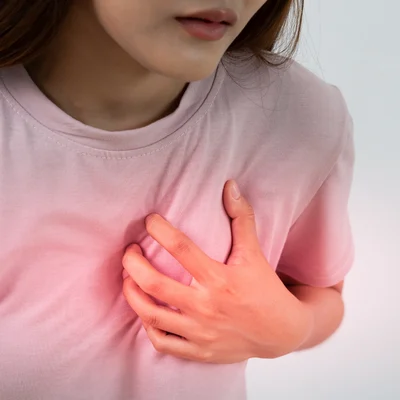 Heart disease in women: what you need to know 3 Woman holding her chest in pain, representing heart disease in women